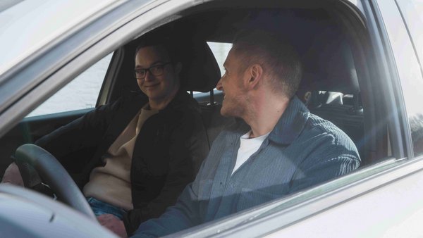 Чи є сенс у автомобілі? Двоє молодих людей сидять в авто та посміхаються однин одному