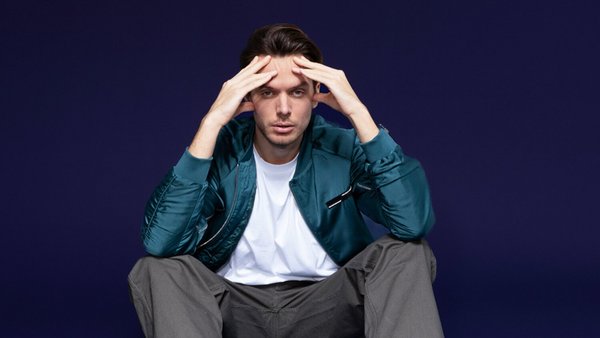 Що таке споживчий кредит? Молодий чоловік сидить на підлозі й стурбовано тримає руки за голову