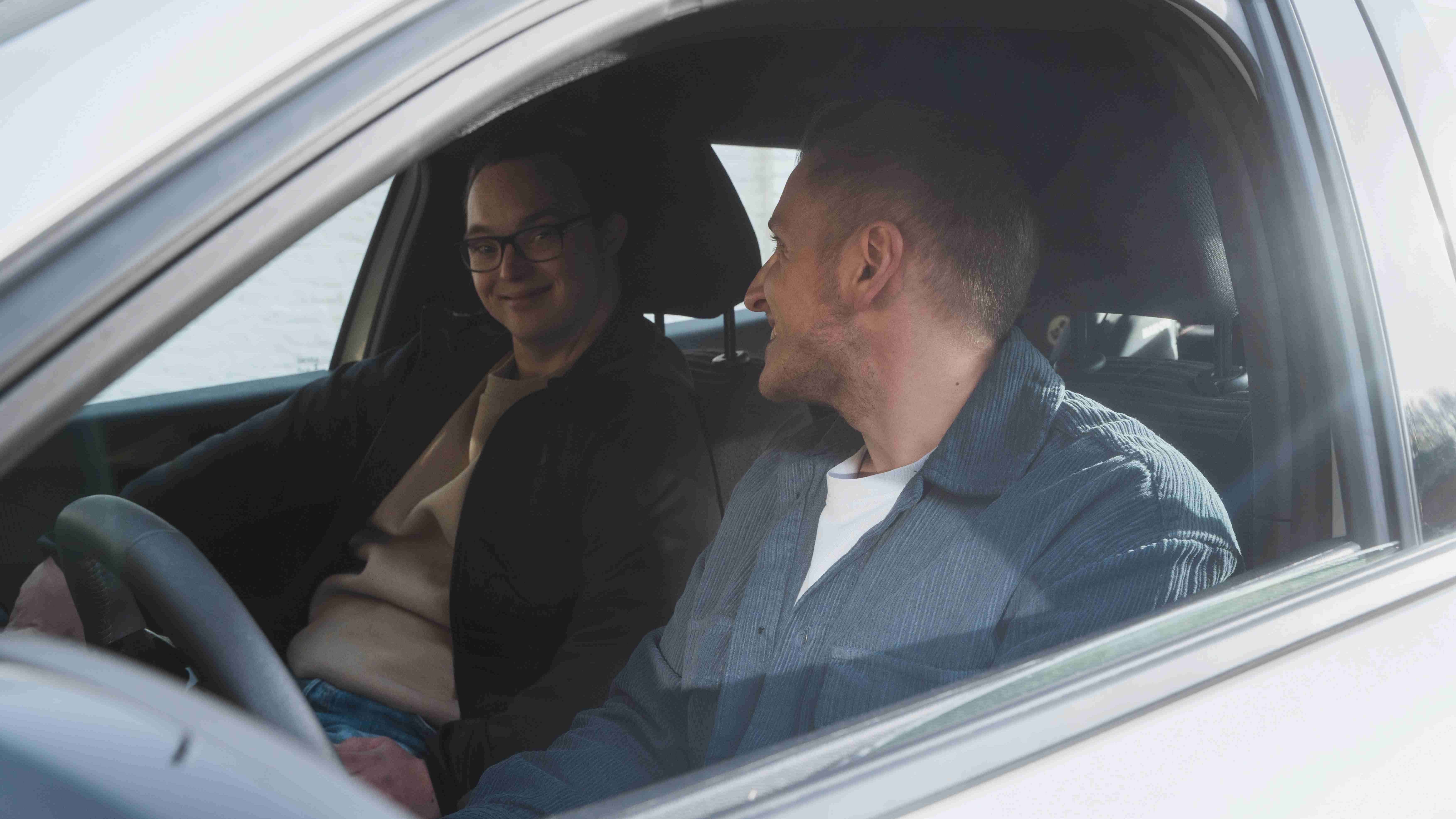 Чи є сенс у автомобілі? Двоє молодих людей сидять в авто та посміхаються однин одному