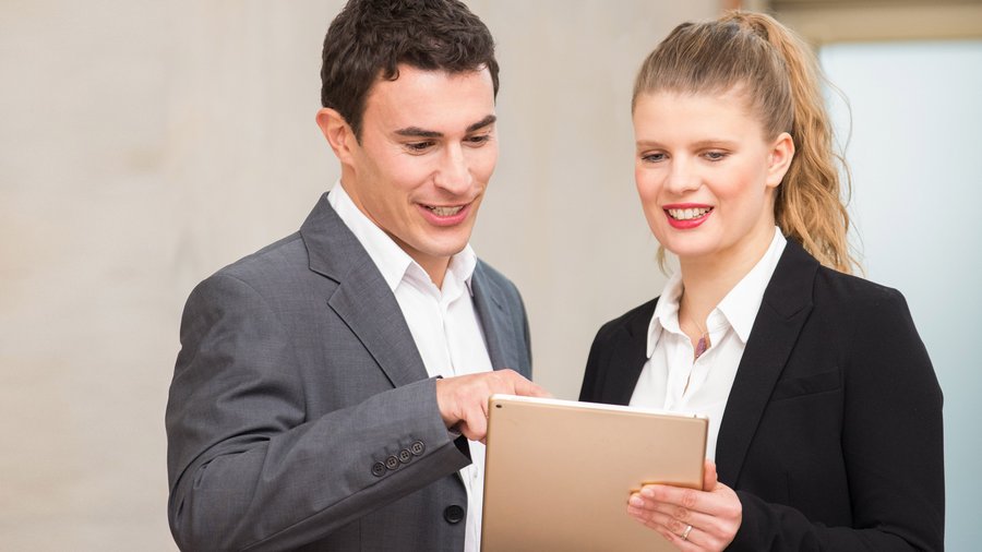 Надійні фінансові партнери Чоловік і жінка разом переглядають документи та посміхаються.